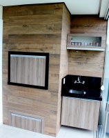 Churrasqueira com balcão de pia e armário aéreo.